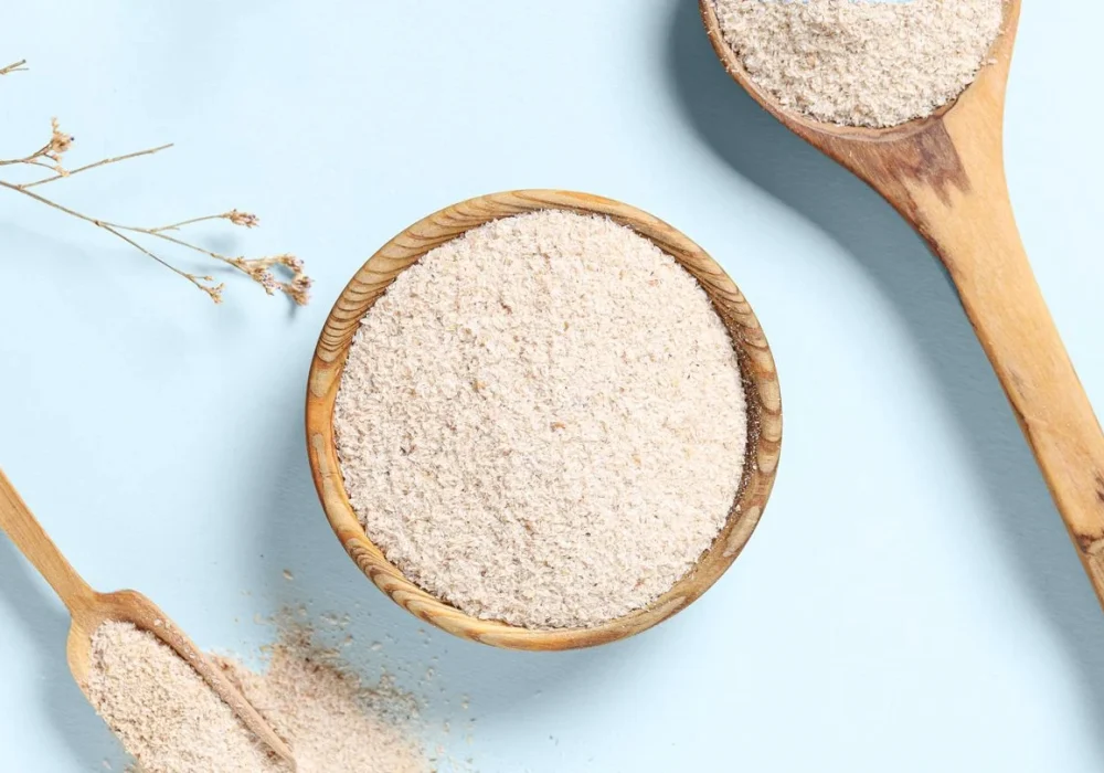 オーガニックのサイリウム・ハスク・パウダーをスプーン1杯分、コップ1杯の水とケト・パンの横に置き、その健康効果と製パン効果を強調する。